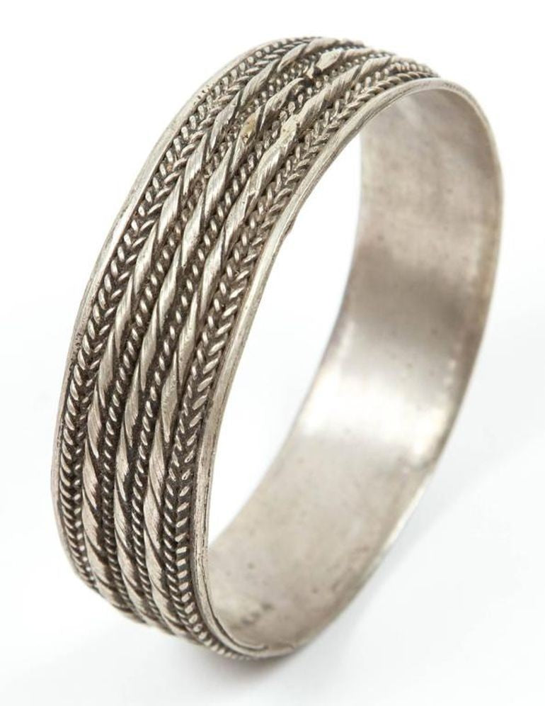Silver ring with intricate design on a white background
