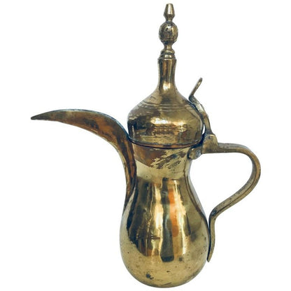 A traditional brass Dallah coffee pot with a large spout and riveted brass finish, featuring hand-hammered and chased Moorish designs.