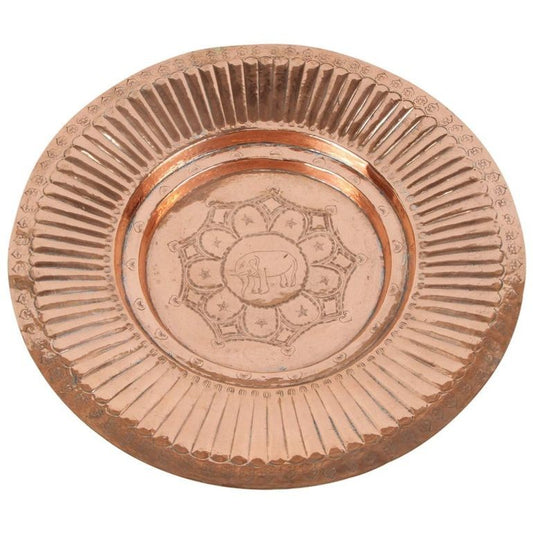 A polished round copper tray with a geometric design in the middle and an elephant in the center, against a light background.