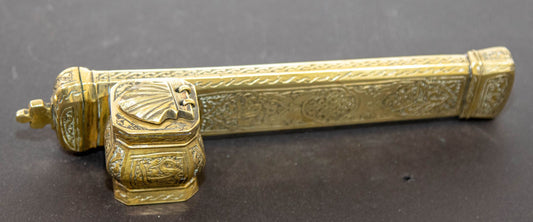 Antique brass inkwell with Arabic calligraphy and decorative elements, featuring a pen compartment and an attached inkwell.