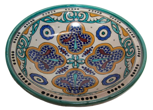 Antique hand-painted Moroccan ceramic bowl with geometric and floral patterns in turquoise, blue, and polychrome colors on a white background.