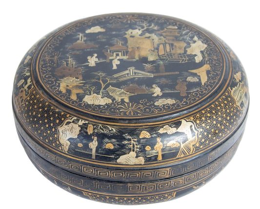 A round black lacquered and gilt painted box with a floral pattern and figures in traditional attire on the lid.