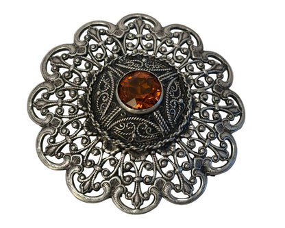 A Turkish silver brooch with Moorish filigree lace design and a central citrine gem stone, from the 1940s.