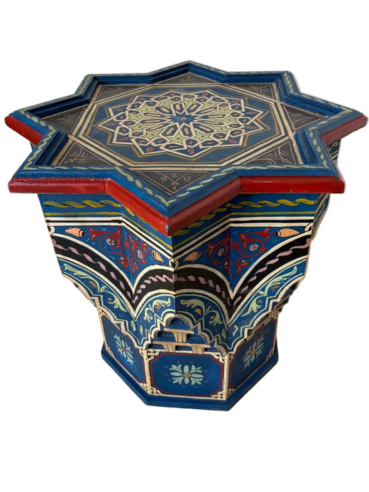 A Moroccan hand-painted blue side table with Moorish Islamic designs, featuring a star-shaped top and an octagonal base.