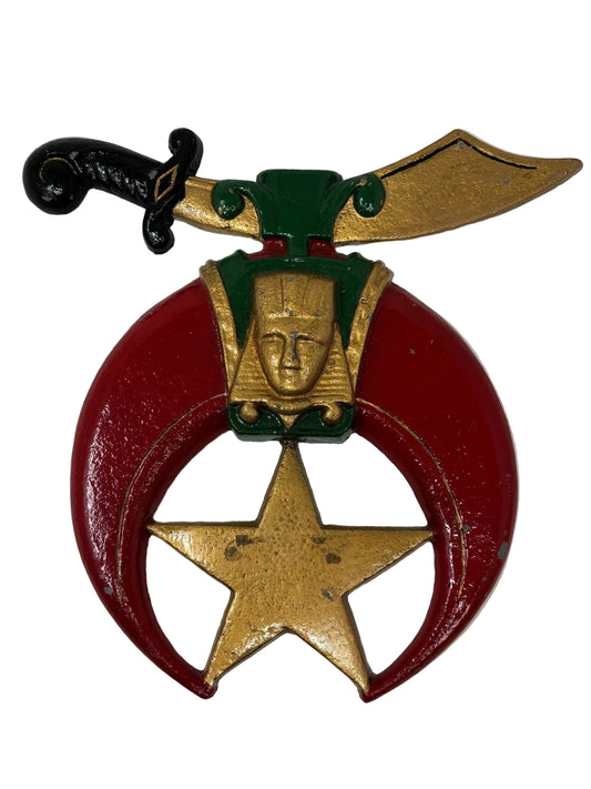 A cast metal emblem wall plaque featuring a crescent moon and scimitar with a gold, red, and green finish, representing Masonic Shriners.