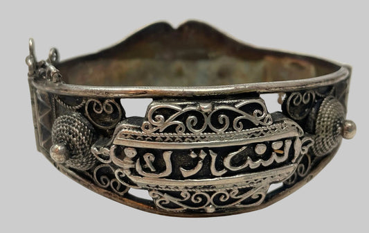 Antique Moorish North African silver cuff bracelet with intricate filigree design and Arabic calligraphy.