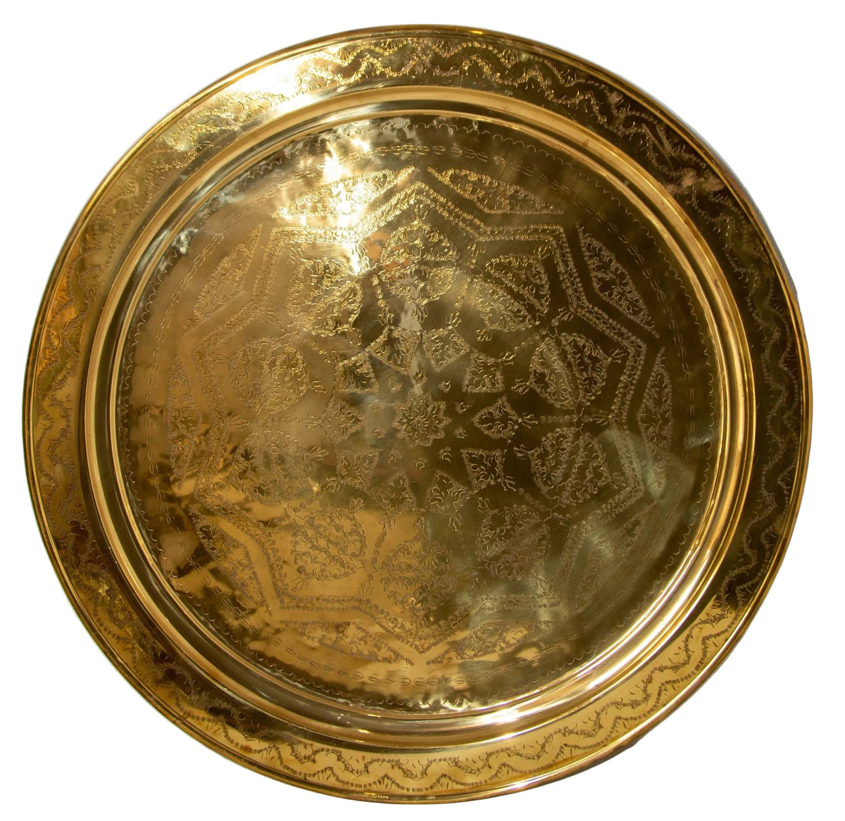 A polished round Moroccan brass tray with intricate geometric patterns.
