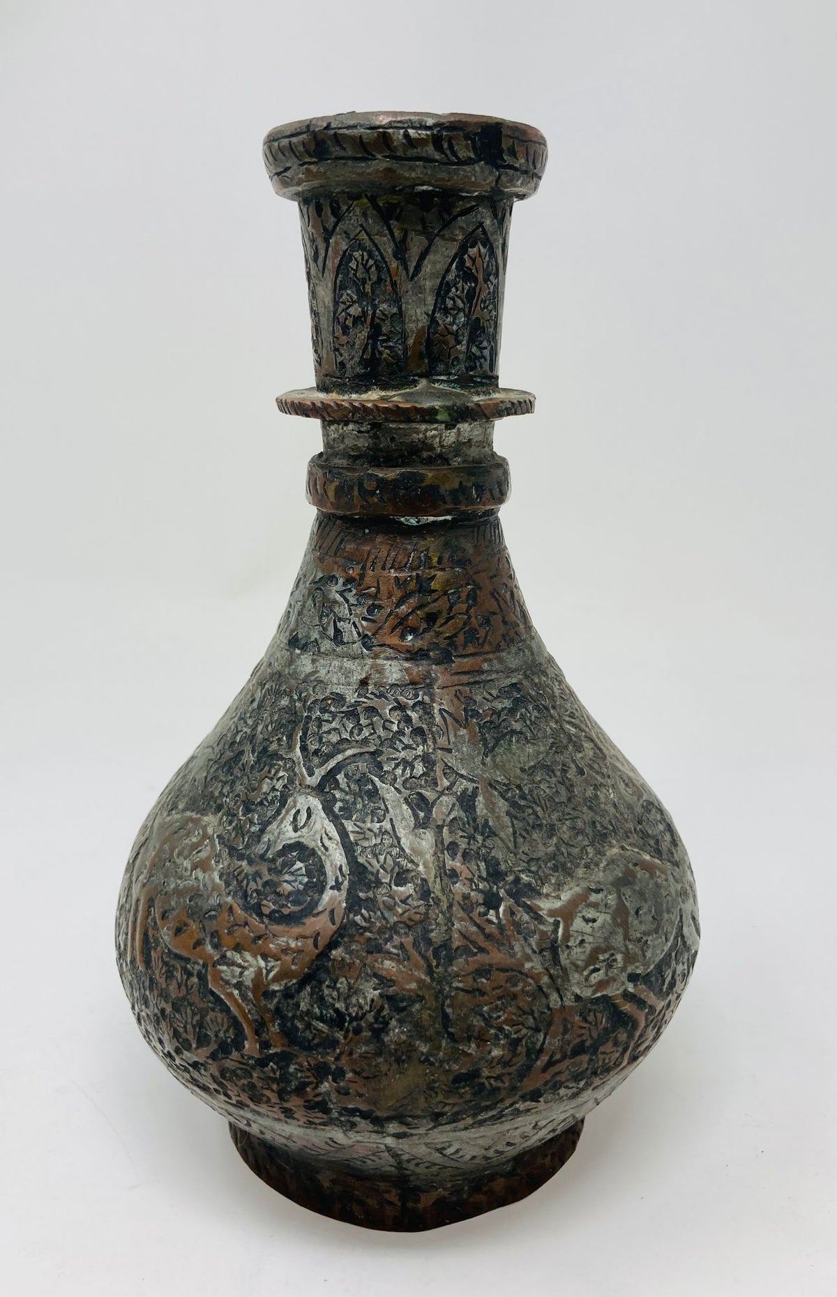 A 19th century tinned copper Indo-Persian Islamic vase with a spherical form, featuring a floral and geometric motif and a deer figure.