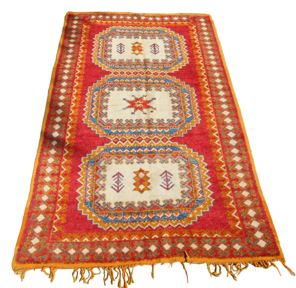 A vibrant orange, blue, pink, ivory, and yellow hand-knotted Moroccan Berber rug with geometric patterns.
