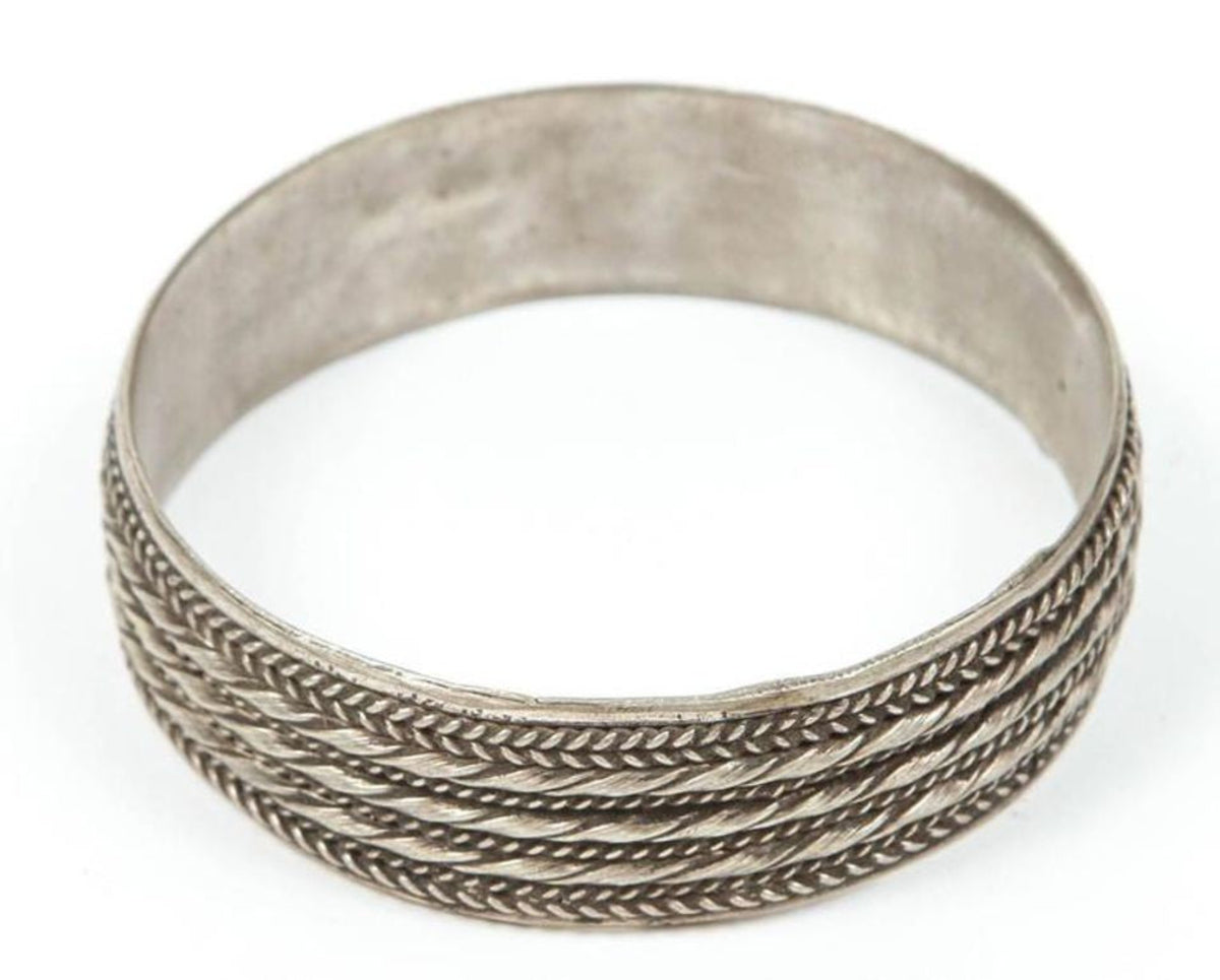 Silver bracelet with braided design on a white background
