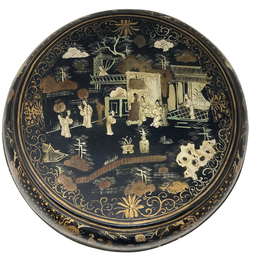 A large Chinese round black lacquered box with gold painted details, featuring an intricate Shanshui style landscape with figures and architectural elements.