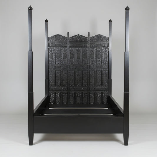 A black four-poster bed with intricate carvings and a Moorish arched head panel, Indo Portuguese Moorish Mughal Raj queen Bed, Anglo Indian hand-carved Bed.
