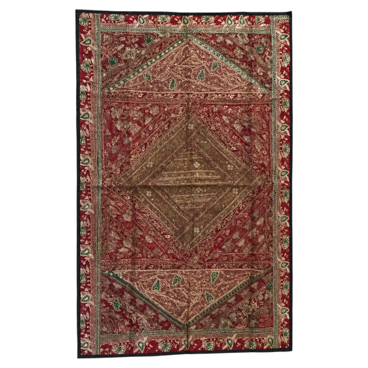 An antique-style Persian rug with a complex geometric and floral pattern, featuring a dominant red field, a central brown medallion, and a dark border with green and beige accents.