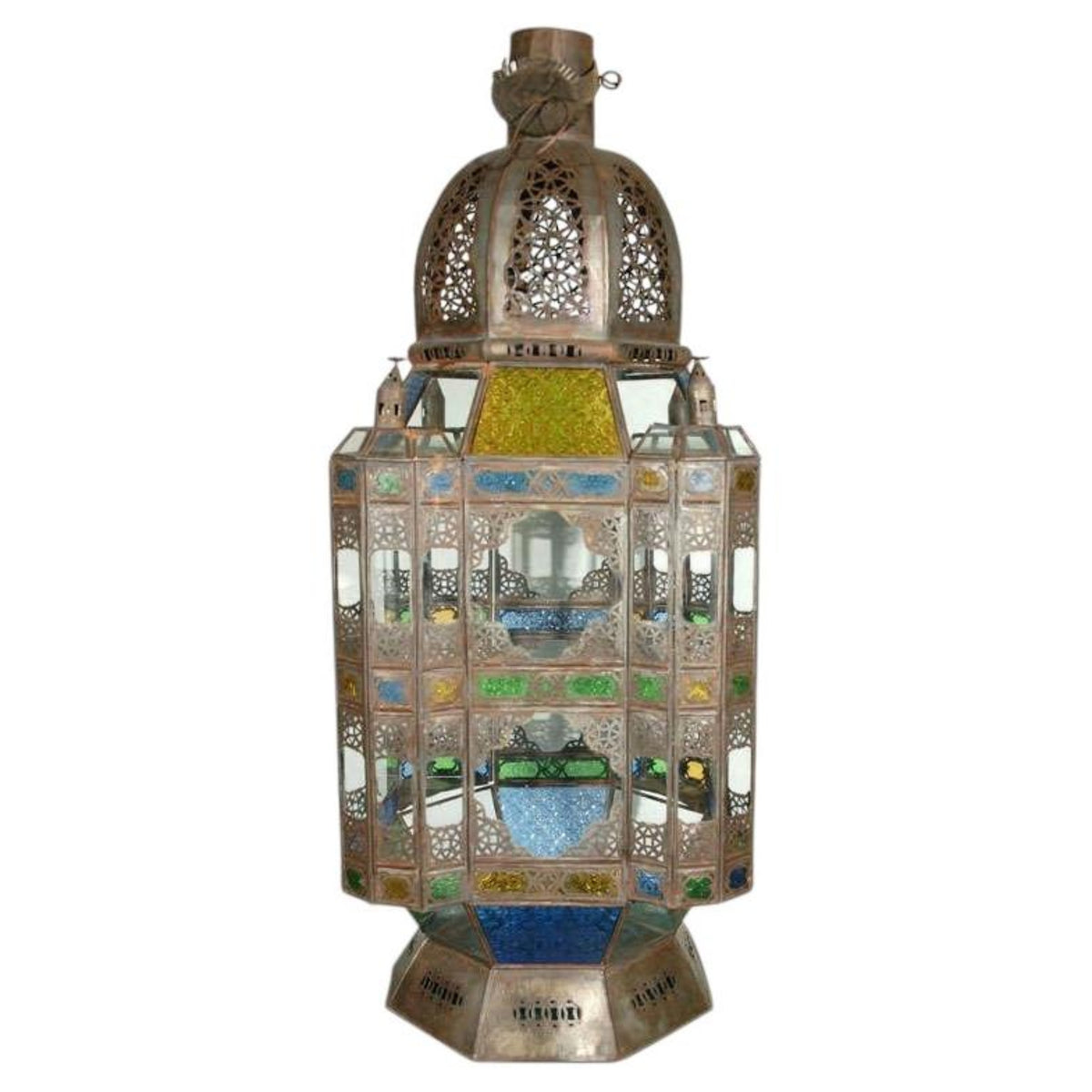 An ornate Moroccan-style metal lantern with intricate cutout patterns and colorful stained glass panels in blue, green, yellow, and white, set against a plain white background.