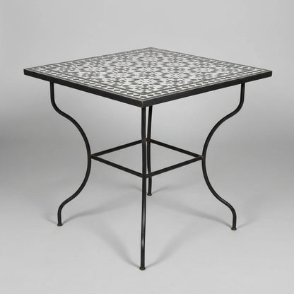 A Moroccan square table with a black and white geometric mosaic tile top and a black metal frame, 