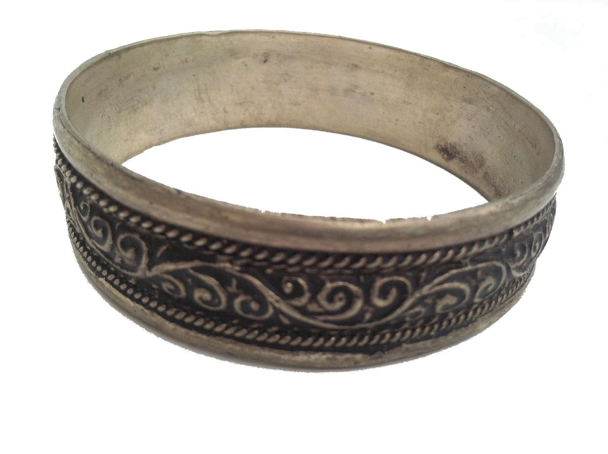 A vintage silver bracelet with intricate geometric patterns, likely made in Morocco.